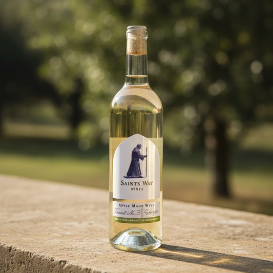 A bottle of Saint's Way Wines Apple Wine, featuring a white label with a dark blue saint illustration